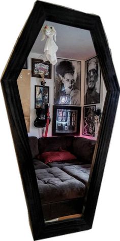 a living room with pictures on the wall and a couch in front of a mirror