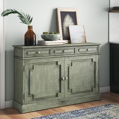 a green cabinet sitting on top of a hard wood floor next to a blue rug