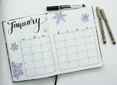 an open planner with snowflakes on it next to two markers and a pen