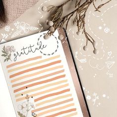 an open planner with flowers on it and a plant next to the page that says gratitude