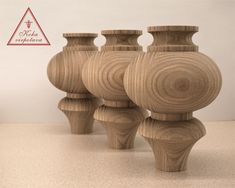 four wooden vases sitting next to each other on top of a white countertop