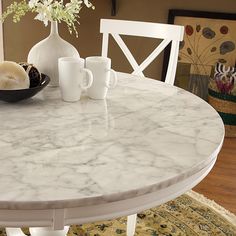 a marble table with white chairs around it