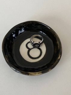 a black and white bowl with two rings in it