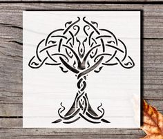 an image of a tree that is drawn on wood with leaves around it and the word,