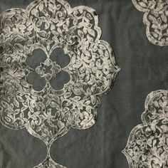 an intricately designed piece of cloth with white lace on it's edges and sides