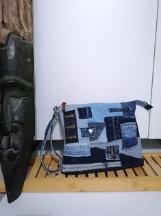 a purse made out of old jeans sitting on top of a wooden shelf