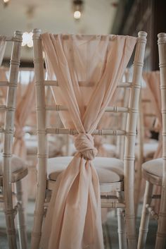 the chairs are lined up with pink sashes