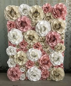 a large flowered wall hanging on the side of a building with white and pink flowers