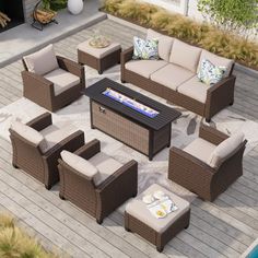 an outdoor patio furniture set with beige cushions and brown wicker chairs, coffee table and fire pit