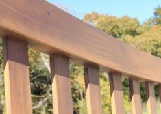 a close up view of a wooden fence with trees in the backgrouds