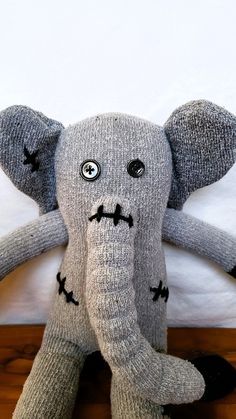 an elephant stuffed animal sitting on top of a wooden floor