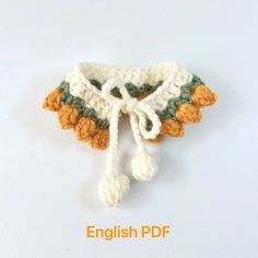 a crocheted piece of clothing on a white surface with a knot at the end