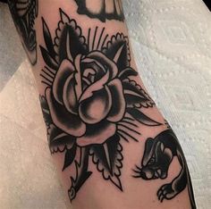 a black and white rose tattoo on the arm