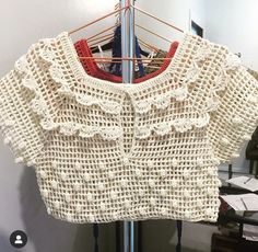 a crocheted sweater hanging on a clothes rack