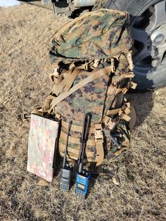 an army backpack and other items sitting on the ground