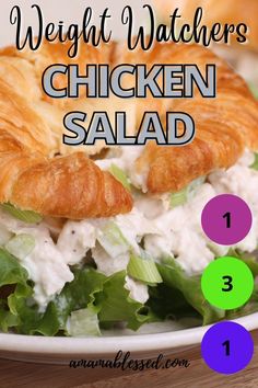 a chicken salad with croissants and lettuce in it on a white plate