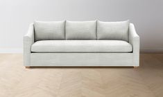 a white couch sitting on top of a wooden floor