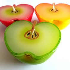 three apple shaped candles sitting next to each other