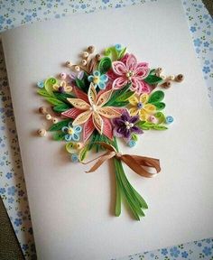 a bouquet of flowers made out of paper on top of a piece of white paper