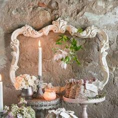 a table topped with cakes and candles next to a wall covered in peeling plaster walls