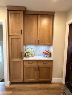 a kitchen with wooden cabinets and white counter tops