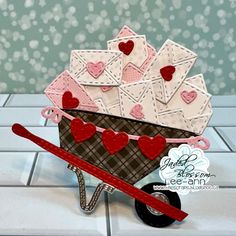 a handmade card in the shape of a wagon filled with envelopes and hearts