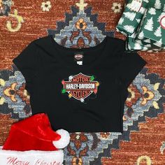 the harley davidson shirt is next to a christmas hat and gift wrapper on a carpet