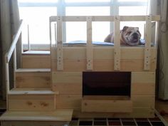 a dog laying on top of a bed made out of wooden pallets and stairs