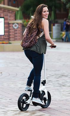 a woman is riding an electric scooter