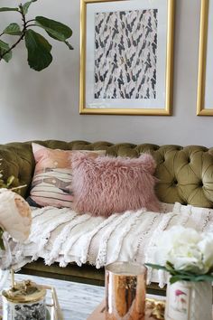 a green couch with pink and white pillows