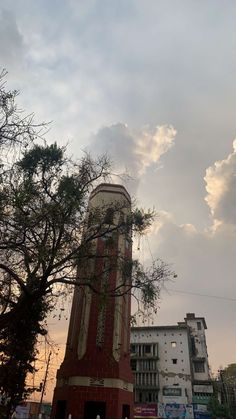 a tall clock tower sitting in the middle of a city under a cloudy blue sky