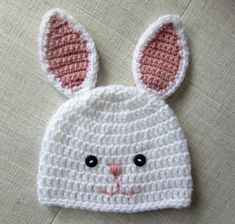 a crocheted bunny hat with ears on it's head and eyes are shown