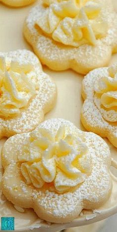 some cookies with icing and flowers are on a plate