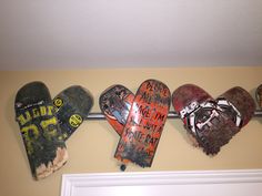 three heart shaped skateboards are hanging on the wall