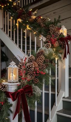 a christmas garland with pine cones and red ribbon on the banister next to stairs