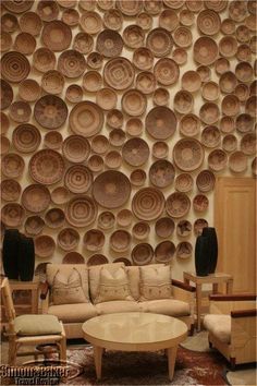 a living room filled with furniture next to a wall covered in plates and bowls on the wall