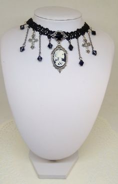 Gothic choker with skull Lady cameo, Black lace necklace with crystals and skull cameo, silver tone crosses, victorian jewelry, Halloween This necklace is made in macramè lace, black crystal beads and silver-tone little crosses. The cameo in the centre, portraying a skeletal lady, measure 2,5 x 1.8 cm and is made in resin. The tray setting is a bit bigger (4,2 x 2,4 cm), silver color metal, beautifully decorated. Lobster clasp fastening with adjustable length chain. Metal tray setting and other Adjustable Gothic Skull Jewelry, Goth Fashion Aesthetic, Vintage Black Skull Jewelry, Victorian Black Choker Jewelry, Handmade Black Victorian Necklace, Gothic Black Cameo Jewelry, Victorian Gothic Choker, Goth Choker Necklaces, Silver Gothic Cameo Jewelry