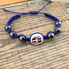 a bracelet with beads and an american flag logo on it is sitting on a wooden surface