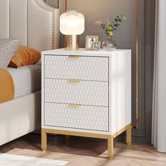 a white and gold nightstand next to a bed