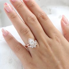 a woman's hand with a diamond ring on her finger and lace doily