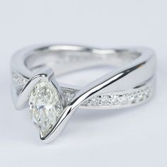 a white gold ring with a diamond in the center and side stones on each band