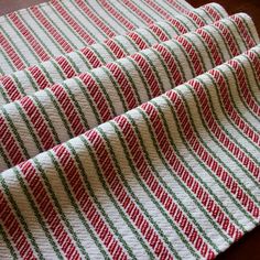 a red and green striped fabric on top of a wooden table