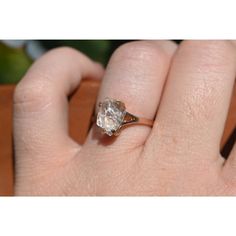 a woman's hand holding an engagement ring with a large diamond on top of it