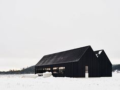 a black building with snow on the ground