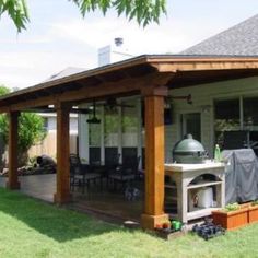 a covered patio with an outdoor kitchen and grill