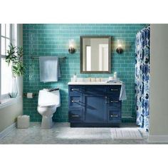 a bathroom with blue and white tiles on the walls, sink, toilet and mirror