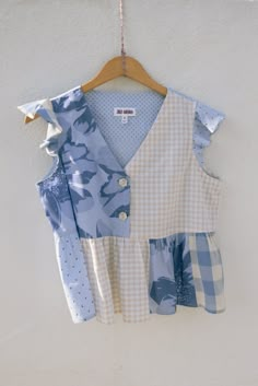 a blue and white shirt hanging on a wall next to a hanger with clothes