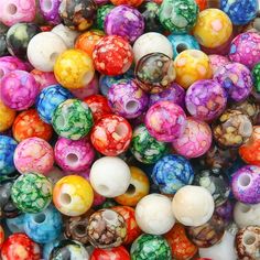 there are many different colors of beads in this pile, and they look like marbles