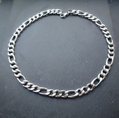 Super chunky figaro/curb chain necklace in silver! Unisex. This necklace is made of high quality stainless steel so is water resistant and won't tarnish or discolour! Available in various sizes. Mens necklace shown in photographs measures 22 inches Womens necklace shown in photographs measures 17 inches. Please don't hesitate to contact me with any queries or suggestions 😊  Comes gift wrapped 💜 Stainless Steel Cuban Link Necklace With Figaro Chain, Silver Stainless Steel Figaro Chain Necklace, Stainless Steel Figaro Chain Necklace, Figaro Chain Necklace, Mens Necklace, Curb Chain Necklace, Figaro Chain, Figaro Chains, Super Chunky