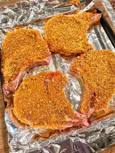 four pieces of meat sitting on top of tin foil